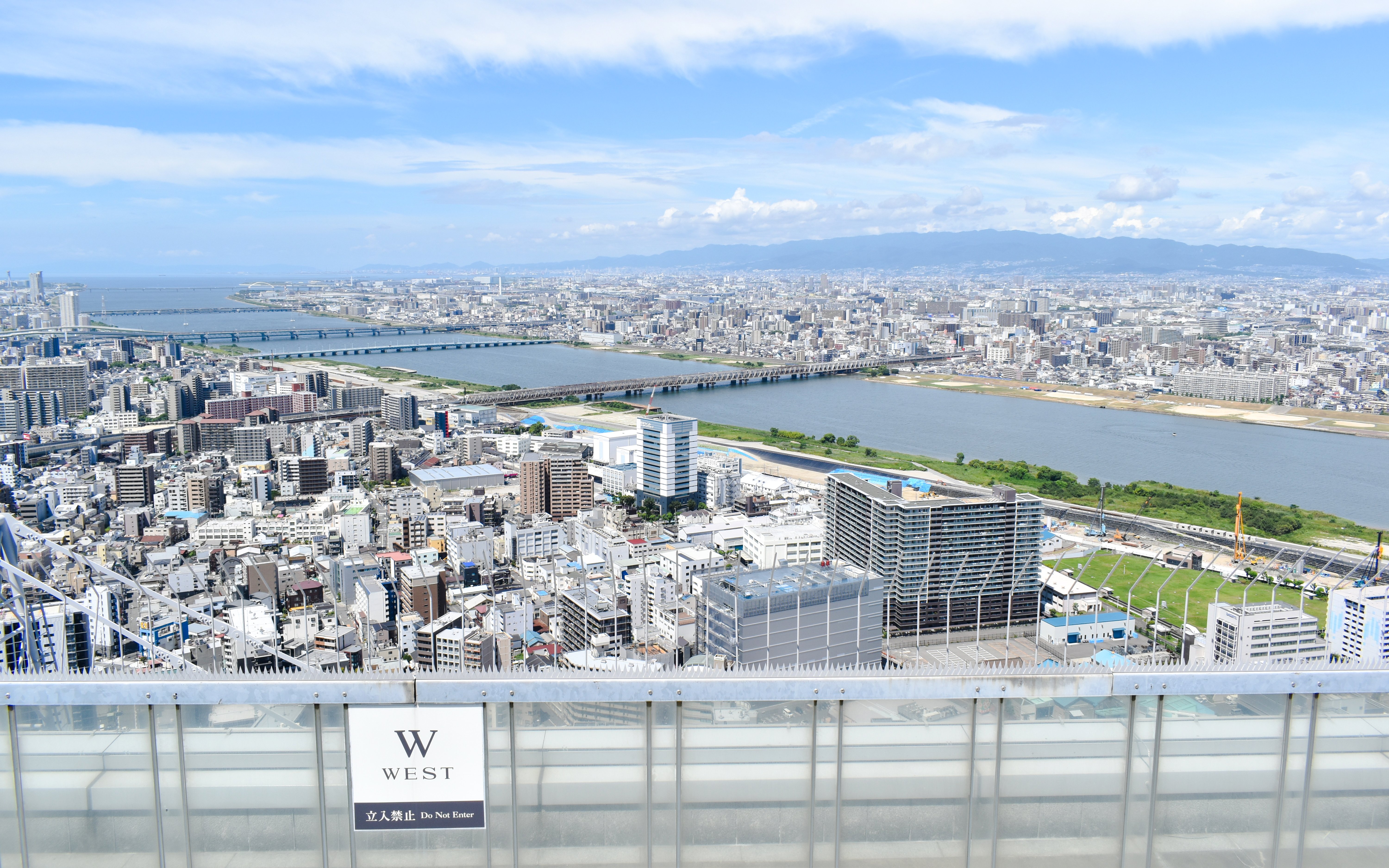 Aerial view from Umeda Sky Building in Osaka, overlooking cityscape and river.