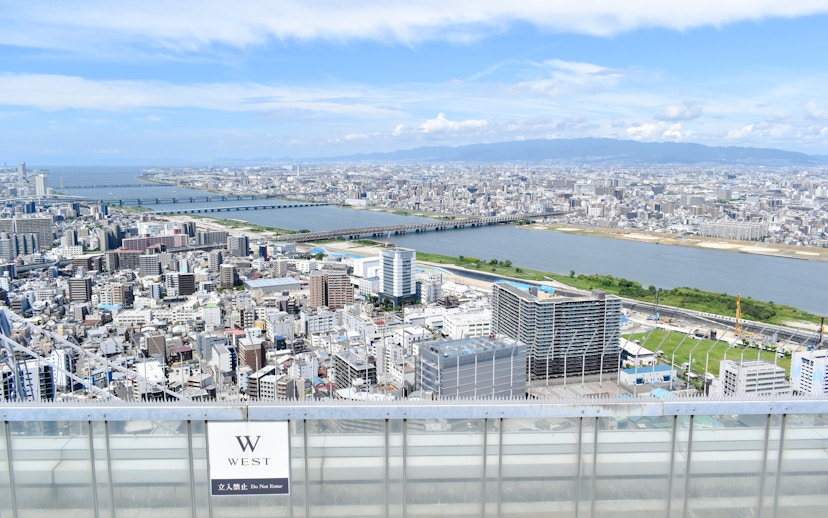 Aerial view from Umeda Sky Building in Osaka, overlooking cityscape and river.