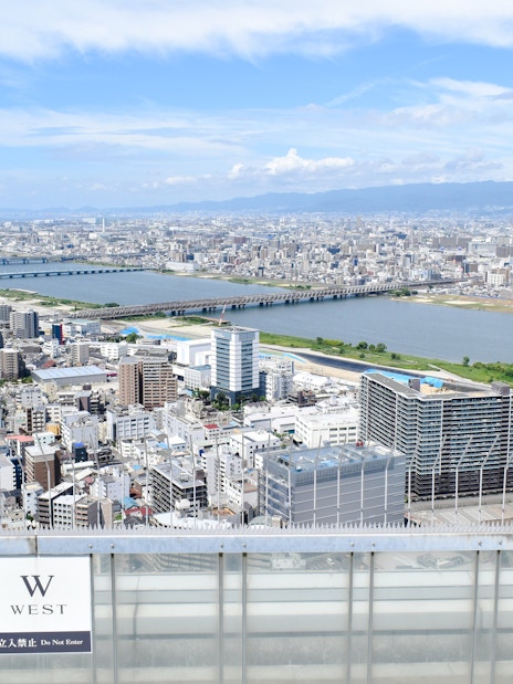 Aerial view from Umeda Sky Building in Osaka, overlooking cityscape and river.