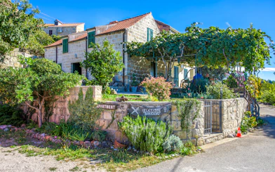 Country House Bakicevo with stone facade and lush garden in Cilipi, Croatia.