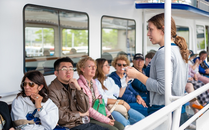 Tour guide explaining safety procedures to passengers on a boat tour.