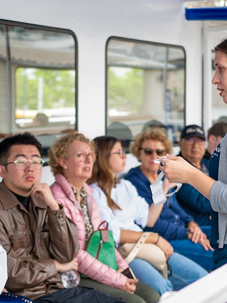 Tour guide explaining safety procedures to passengers on a boat tour.