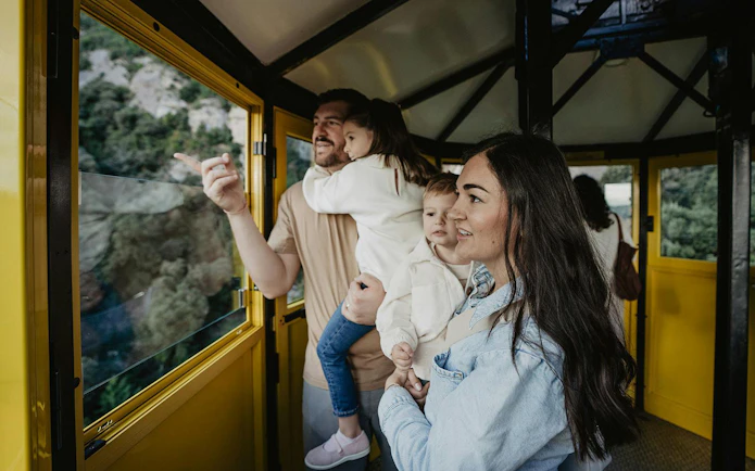 Family enjoying views from Aeri de Montserrat cable car in Spain.