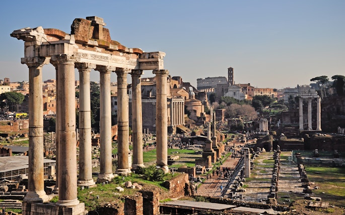 Roman Forum ruins with Colosseum in background, part of Rome hop-on hop-off tour.