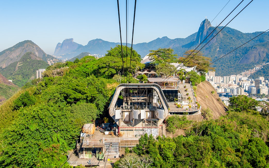 Cable car station on Urca Mountain with Rio de Janeiro cityscape in the background.