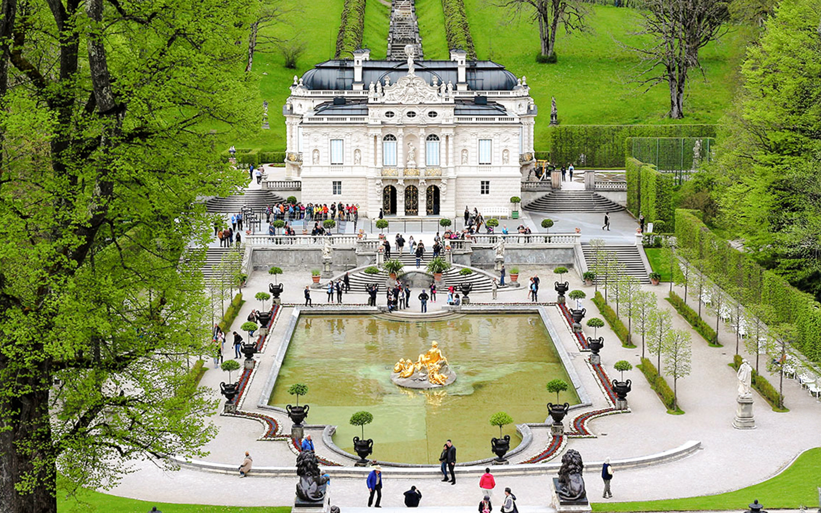 Linderhof Palace gardens with fountain and visitors in Bavaria, Germany.