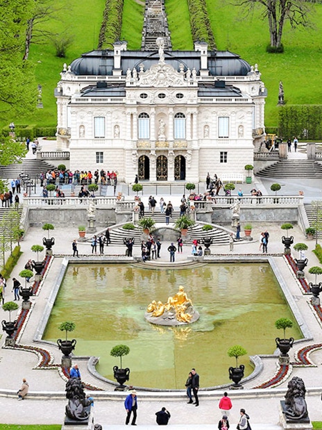 Linderhof Palace gardens with fountain and visitors in Bavaria, Germany.