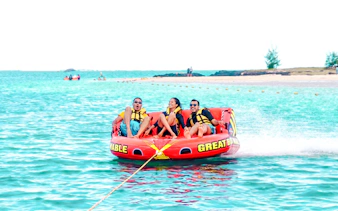 Tube riding adventure near Ile aux Cerf with three people enjoying the ride.
