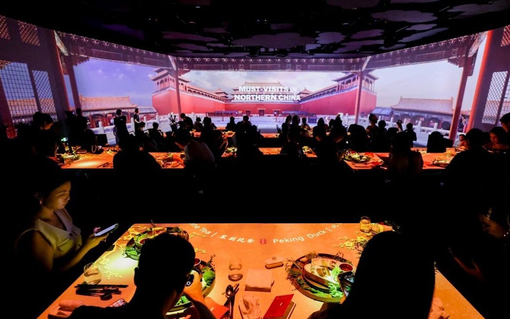 People dining at "Taste of China" immersive restaurant, Shanghai, with Northern China visuals.