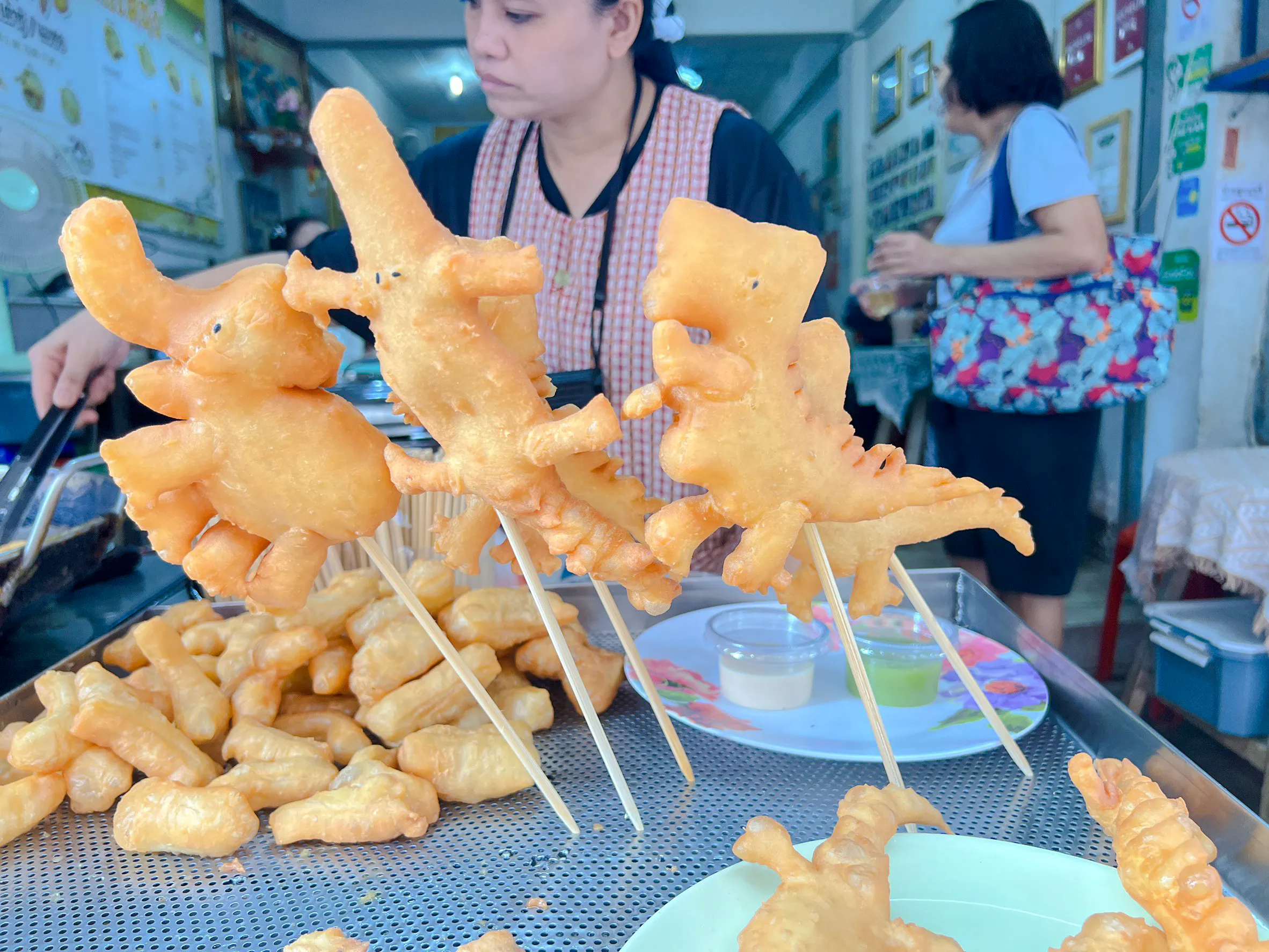 Fried dough shaped like elephants on skewers at a Chiang Mai street food stall.
