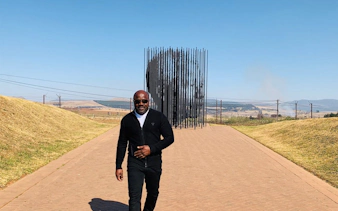 Man walking near the Nelson Mandela Capture Site sculpture in Durban, South Africa.