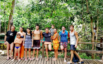 Small group of tourists at Krabi's Emerald Pool during jungle tour.