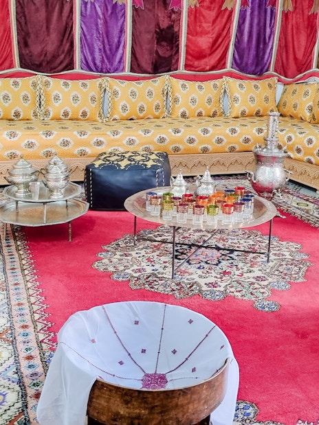 Traditional Moroccan salon with ornate seating and colorful decor in Bahia Palace, Marrakech.