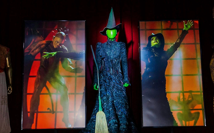 Wicked costume display with broom at RiseNY exhibit.