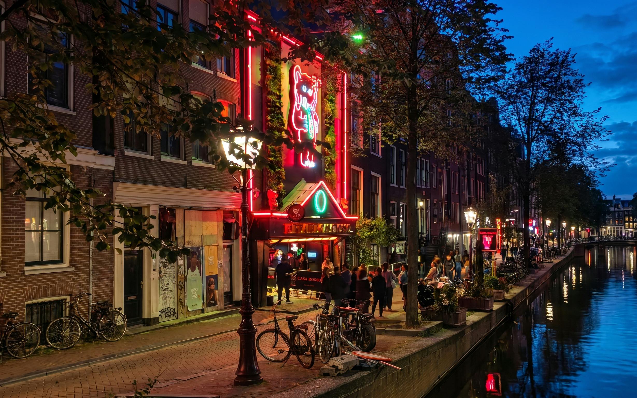 Red Light Secrets Museum entrance in Amsterdam's canal district at night.