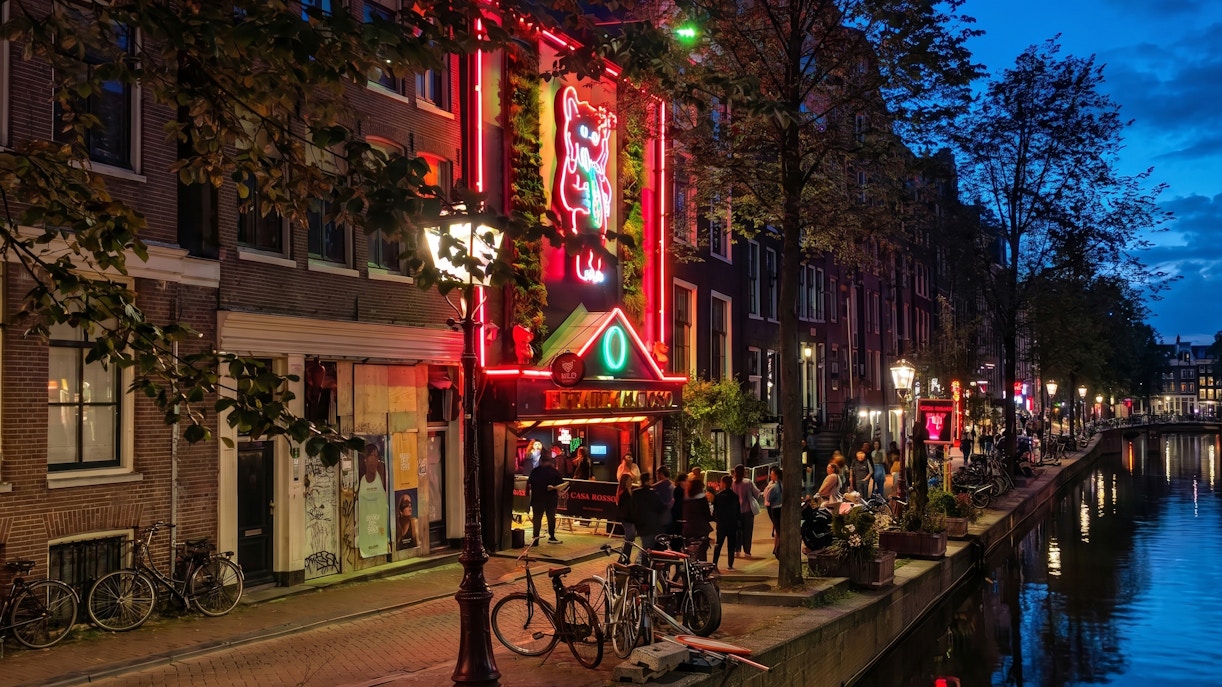 Red Light Secrets Museum entrance in Amsterdam's canal district at night.