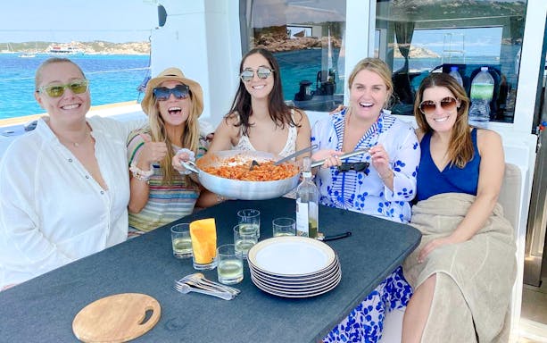 Group enjoying pasta on a catamaran tour in La Maddalena.