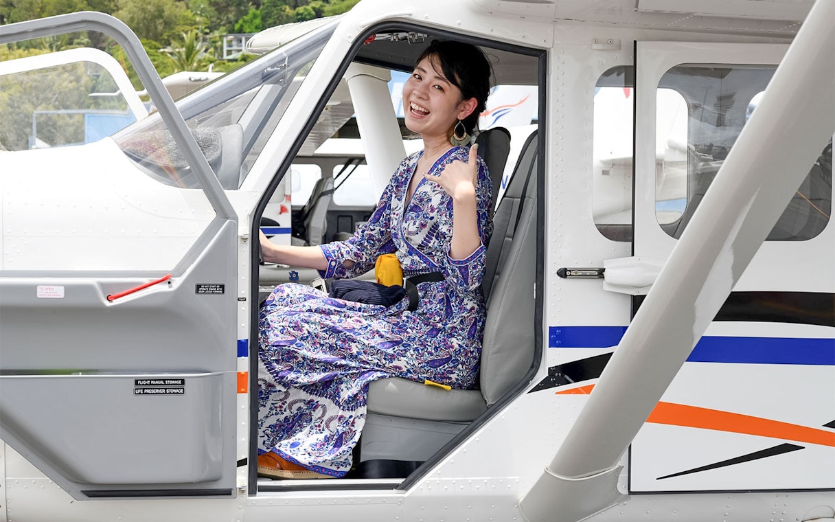 Woman seated in plane for scenic flight to Outer Edges of Great Barrier Reef.