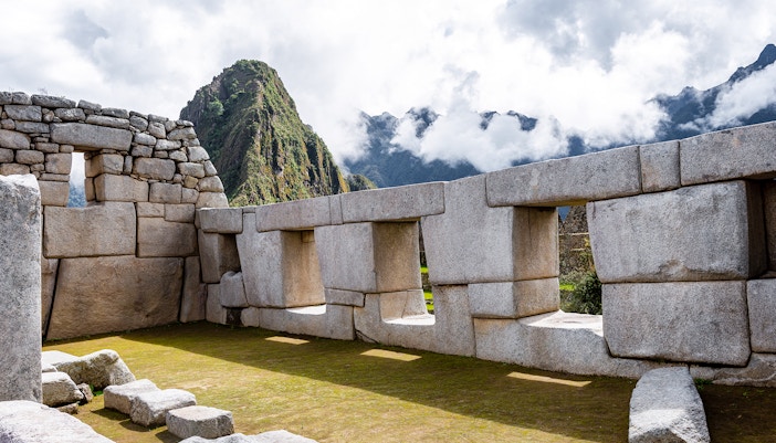 Temple of Three Windows at Machu Picchu with mountain backdrop.
