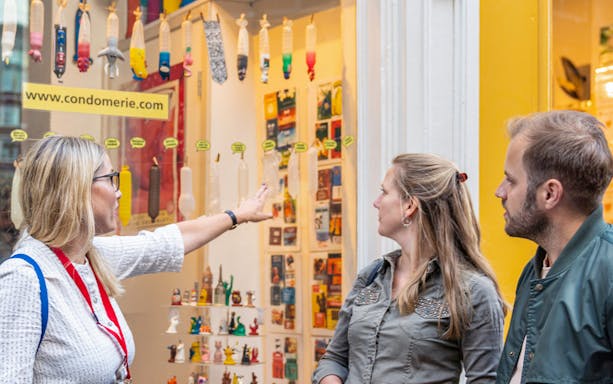 Guide explaining shop display during red light district walking tour.