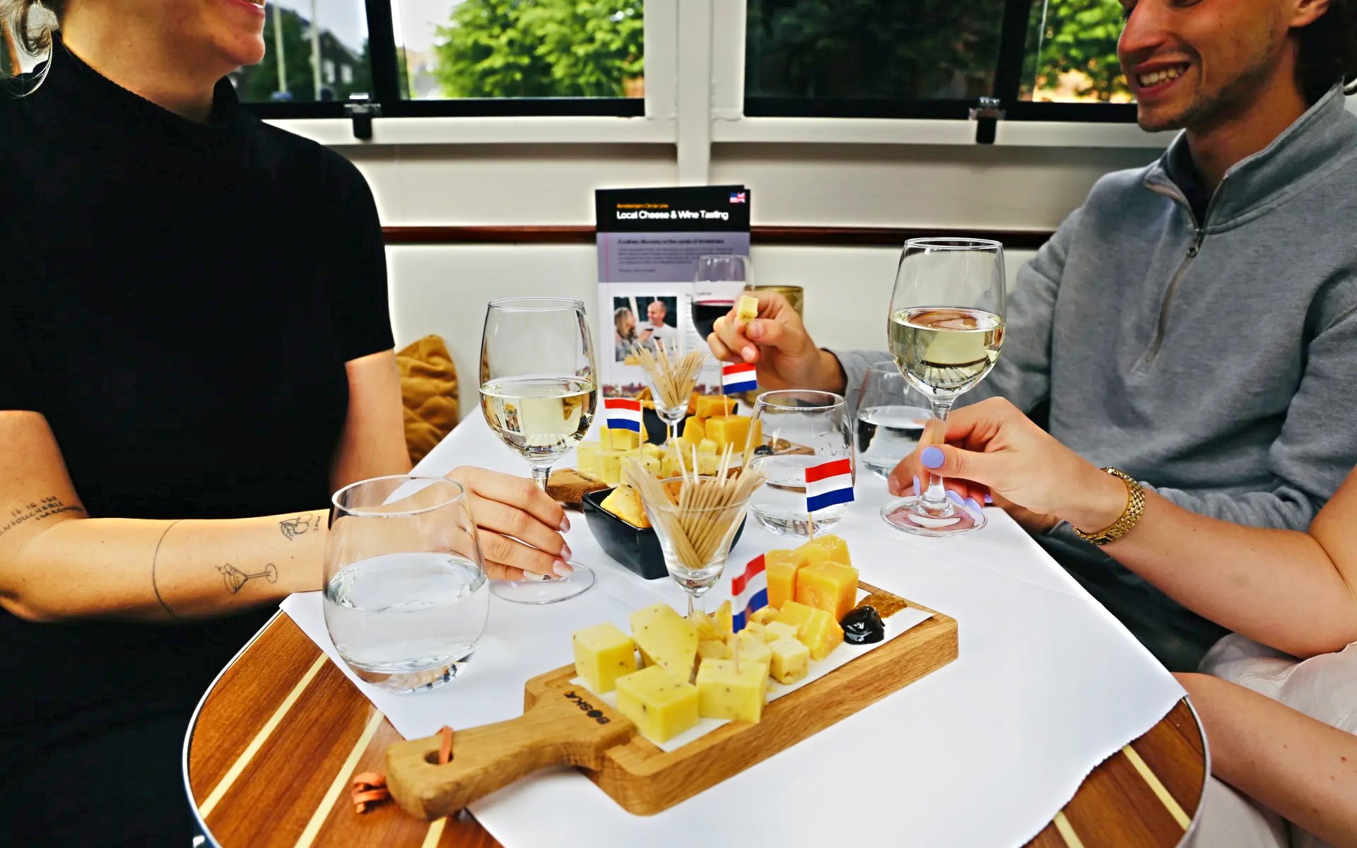 Cheese and wine tasting on a Haarlem cruise with Dutch flags on the table.