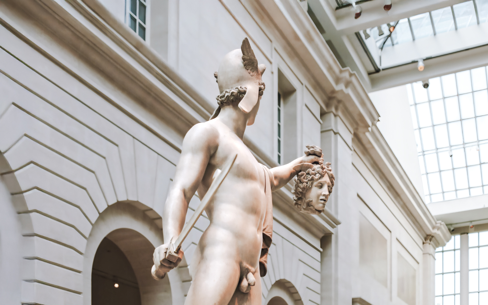 Perseus holding Medusa's head, sculpture by Antonio Canova at a museum.