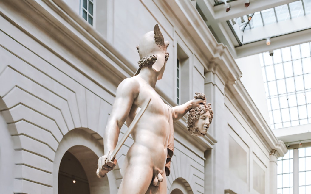Perseus holding Medusa's head, sculpture by Antonio Canova at a museum.