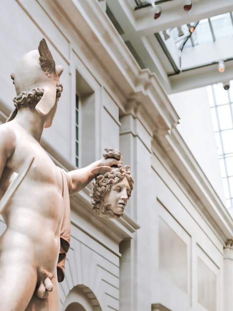 Perseus holding Medusa's head, sculpture by Antonio Canova at a museum.