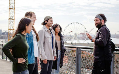 Group enjoying a guided coffee crawl with a view of a Ferris wheel in the background.