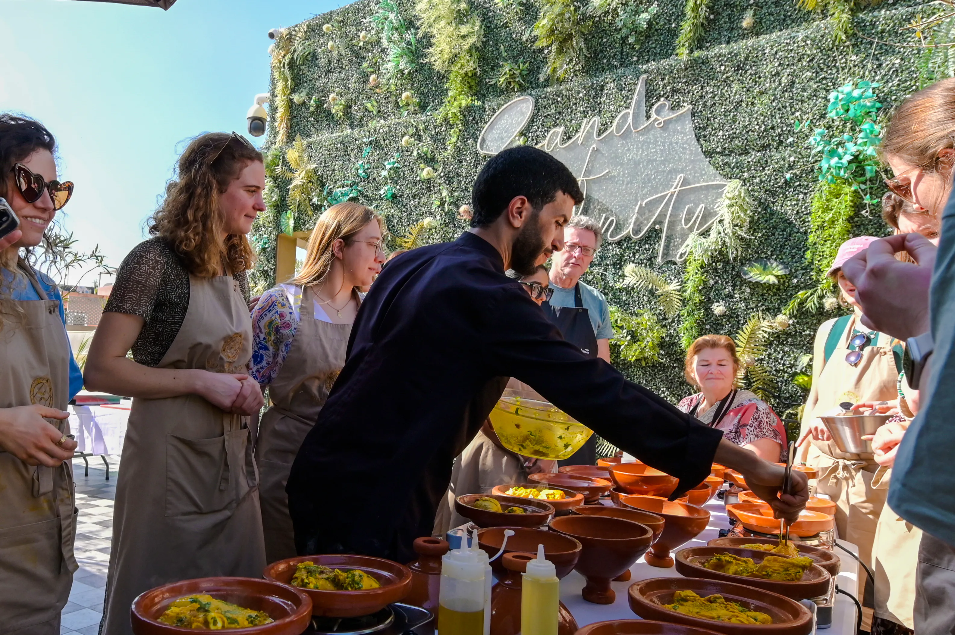 Participants in a Moroccan cooking class on a rooftop in Marrakech, preparing traditional dishes.