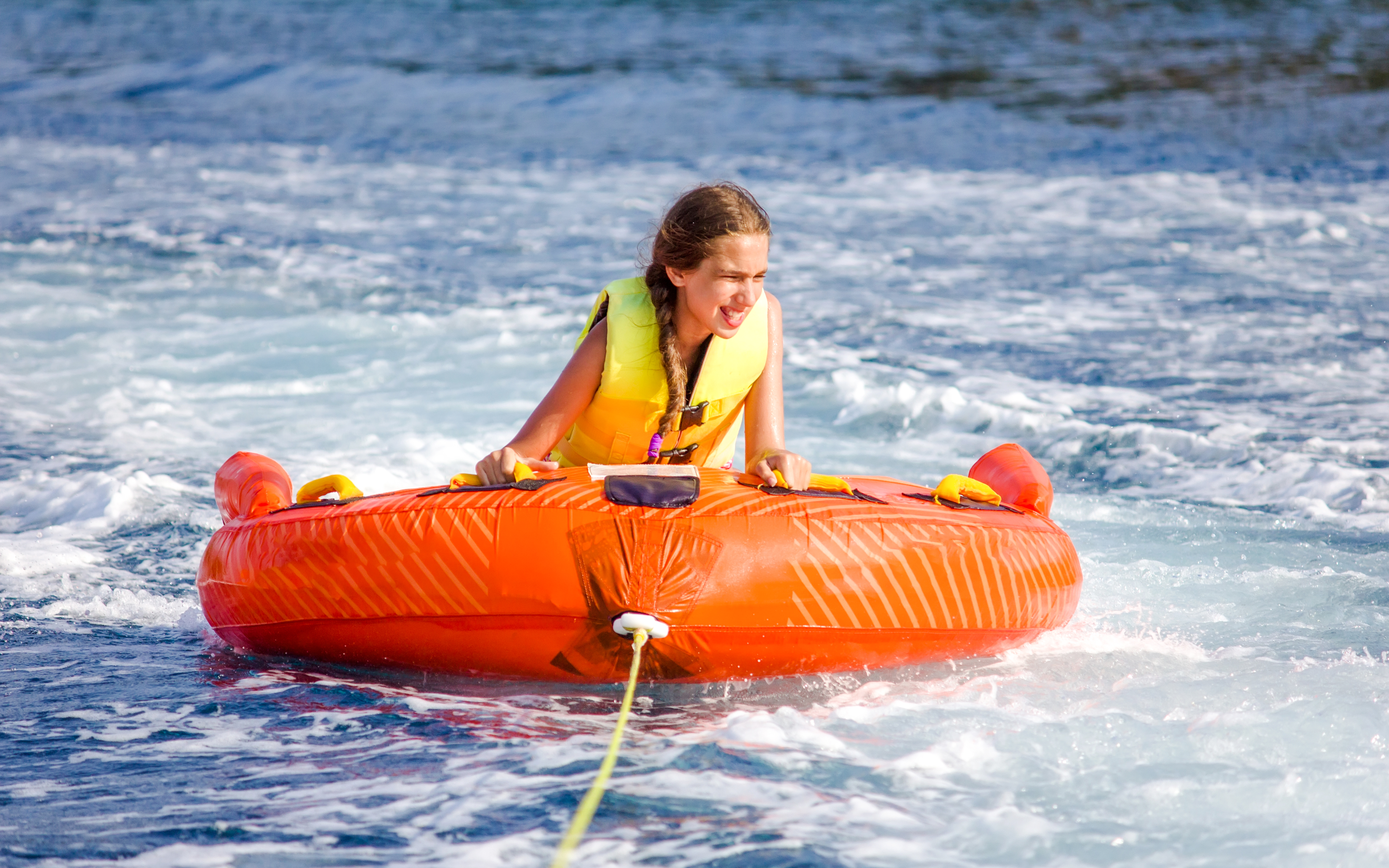 Girl enjoying donut ride water sport in Dubai.