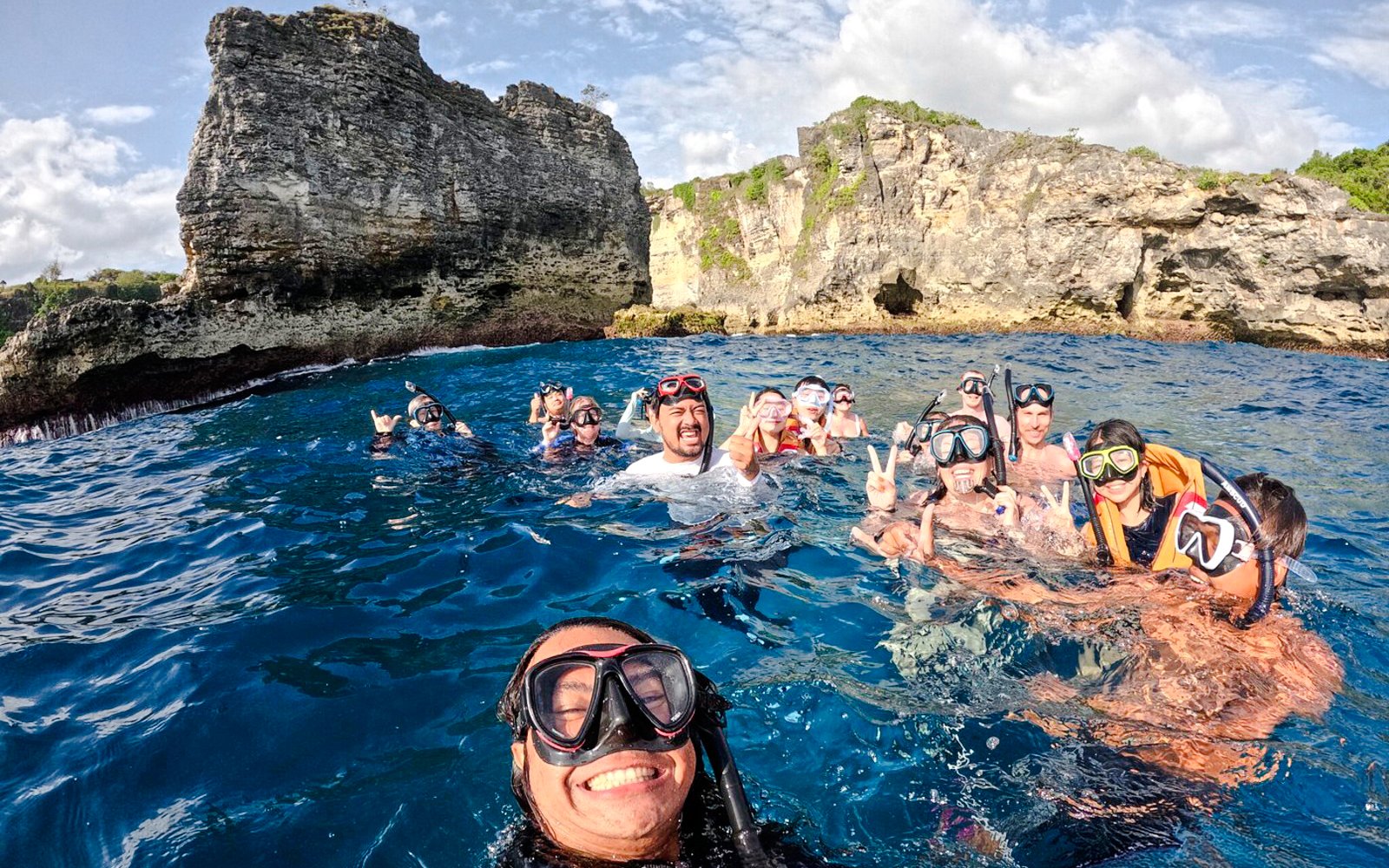 Group snorkeling near cliffs on West Nusa Penida Island tour.