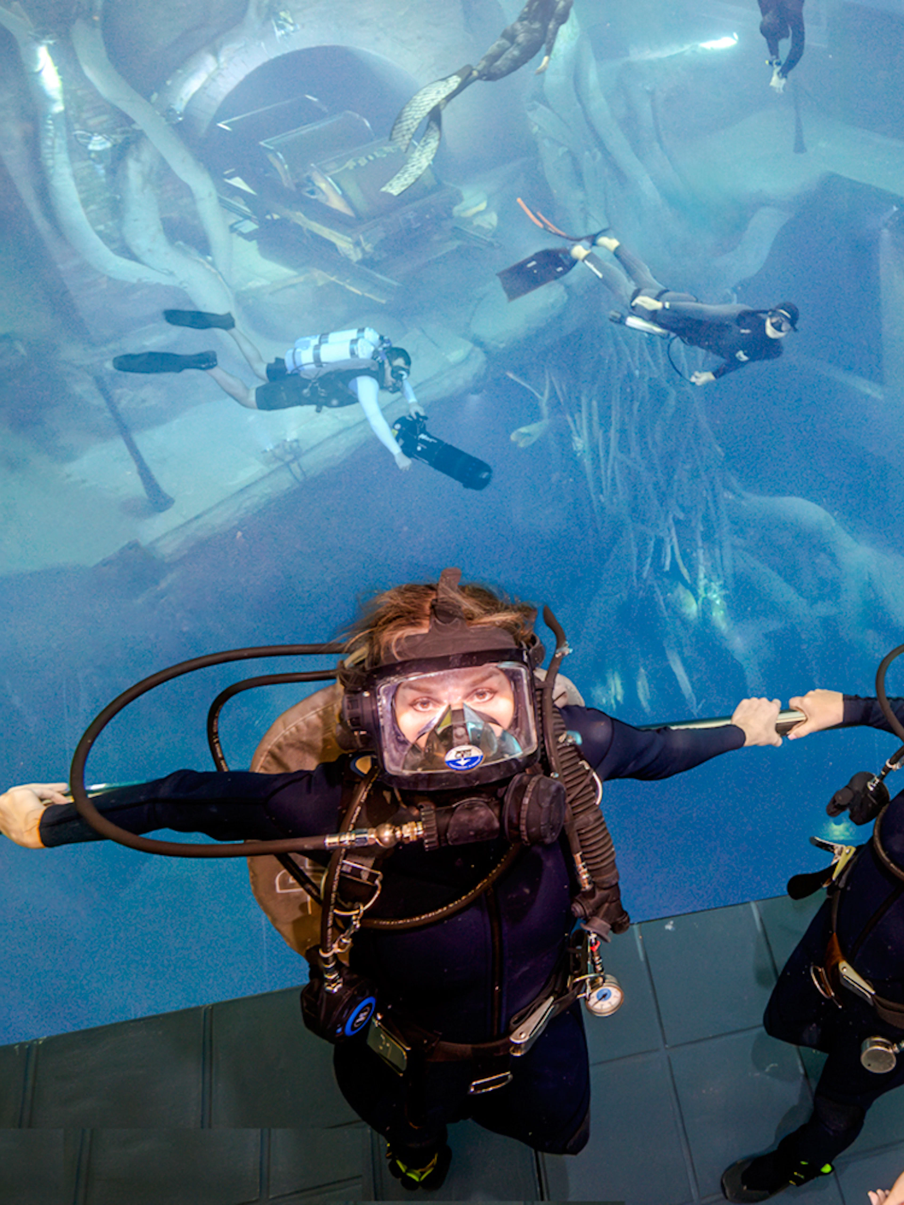 Divers exploring underwater structures during Sunken City Walk tour.