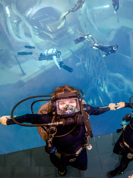 Divers exploring underwater structures during Sunken City Walk tour.