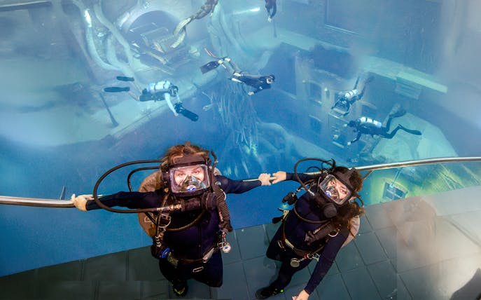 Divers exploring underwater structures during Sunken City Walk tour.