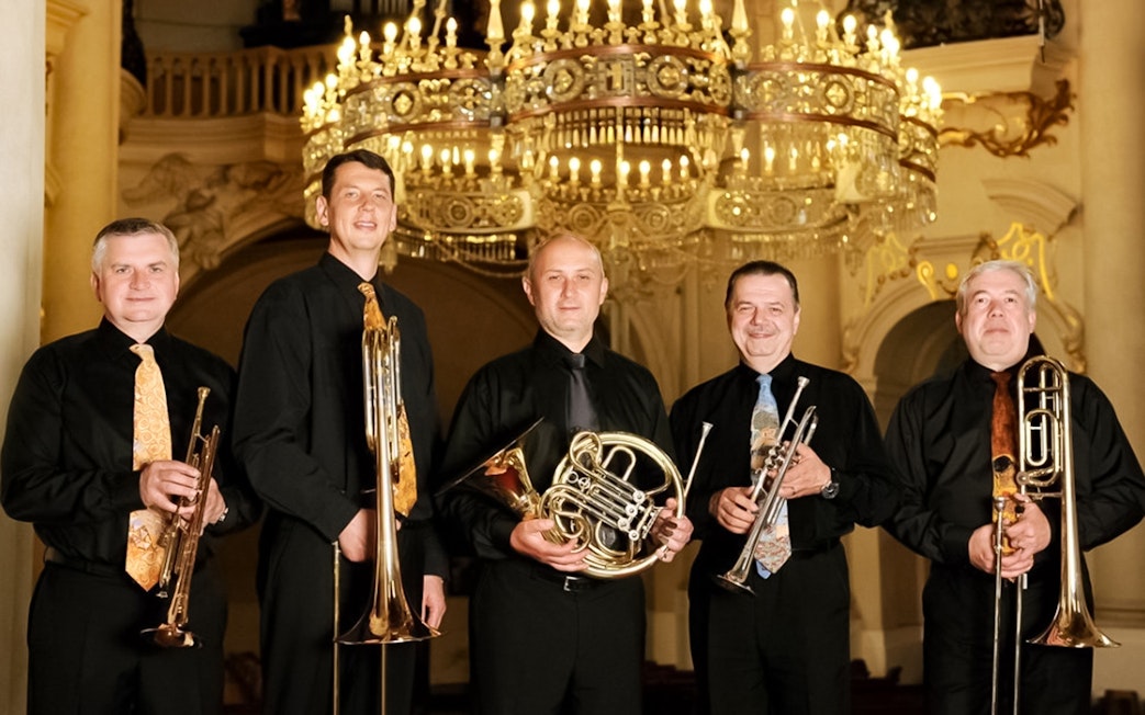 Musicians with brass instruments at St. Nicholas Church concert in Prague.