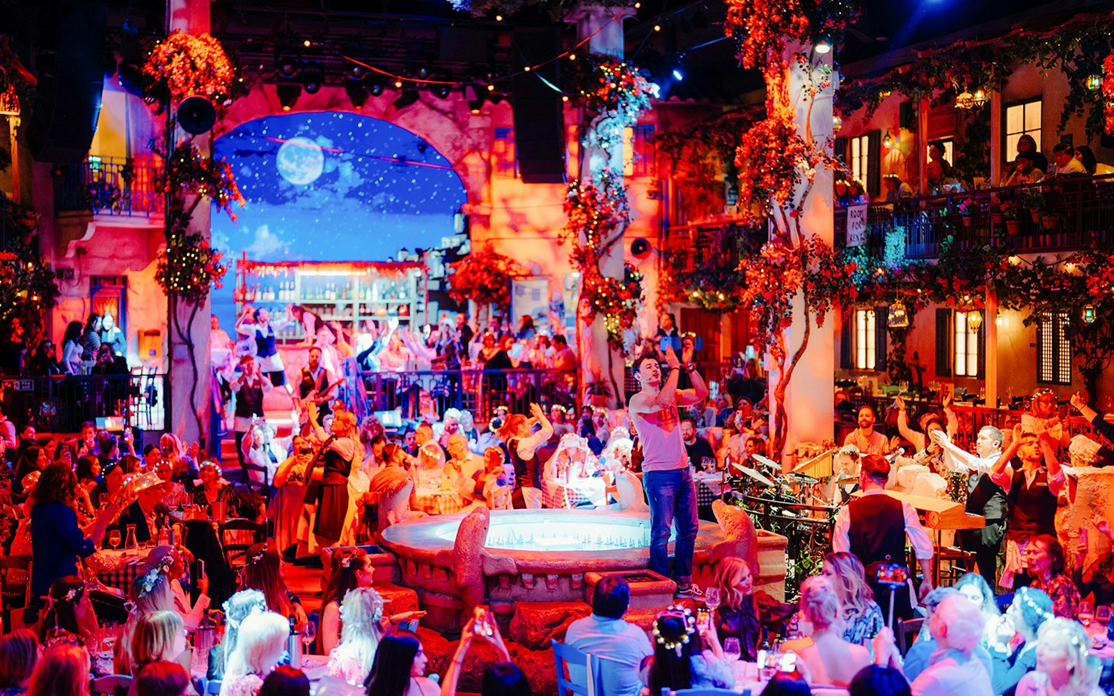 Guests enjoying Mamma Mia! The Party with lively performances and vibrant decor.