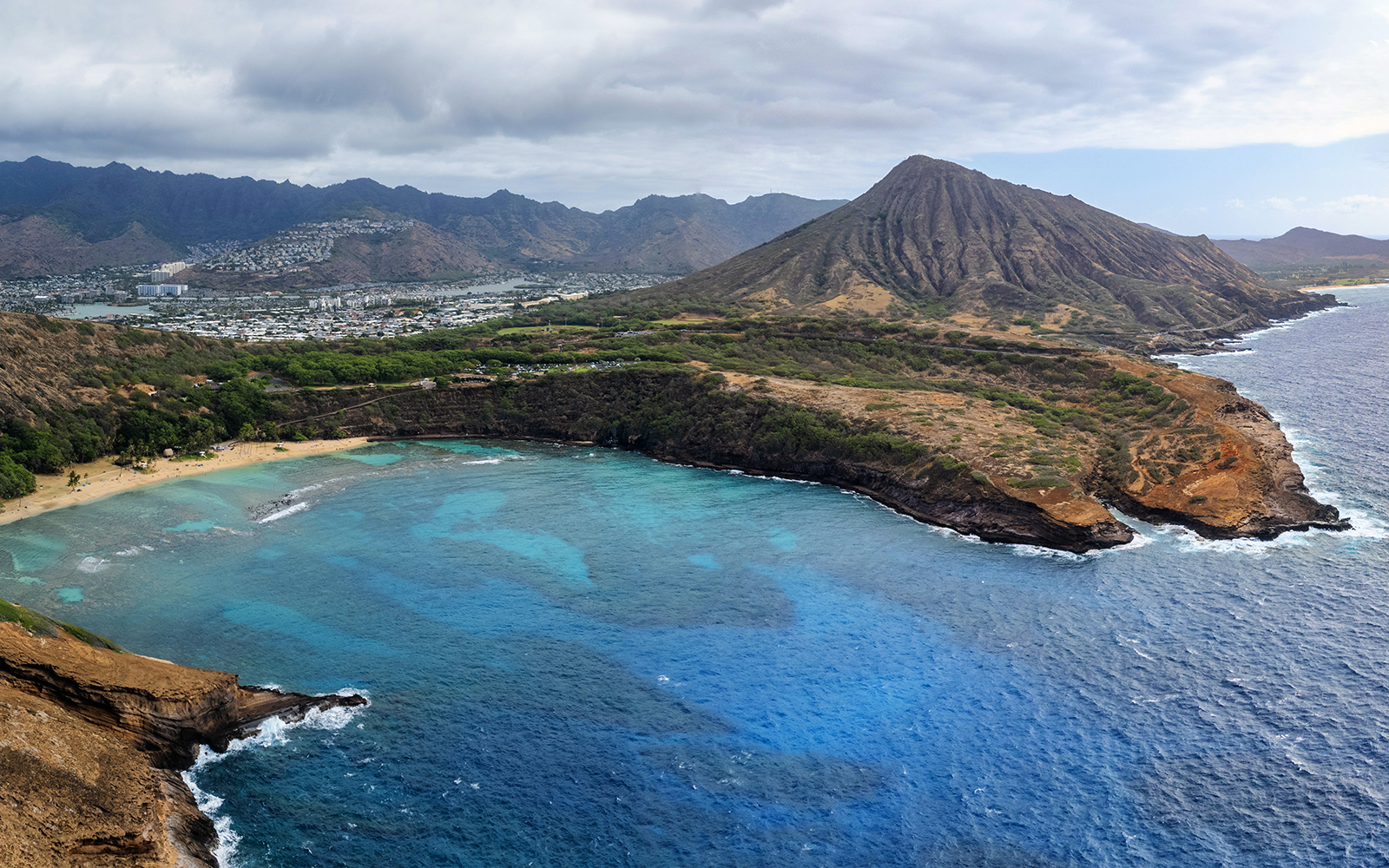 Aerial view of Hanauma Bay beach with Koko Head Crater, Oahu, known for snorkeling.
