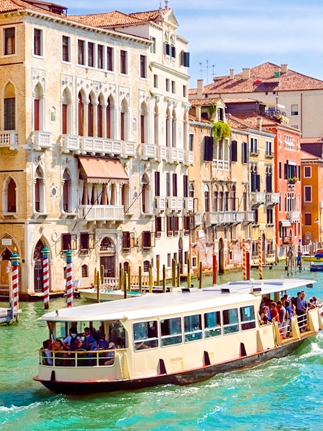 Venice ACTV water bus navigating the Grand Canal with historic buildings in the background.