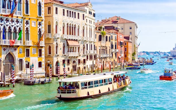 Venice ACTV water bus navigating the Grand Canal with historic buildings in the background.
