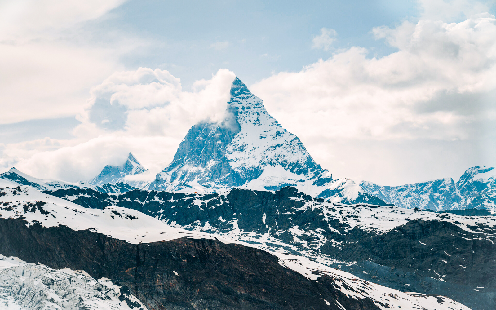 Matterhorn peak surrounded by snow and clouds in the Swiss Alps.