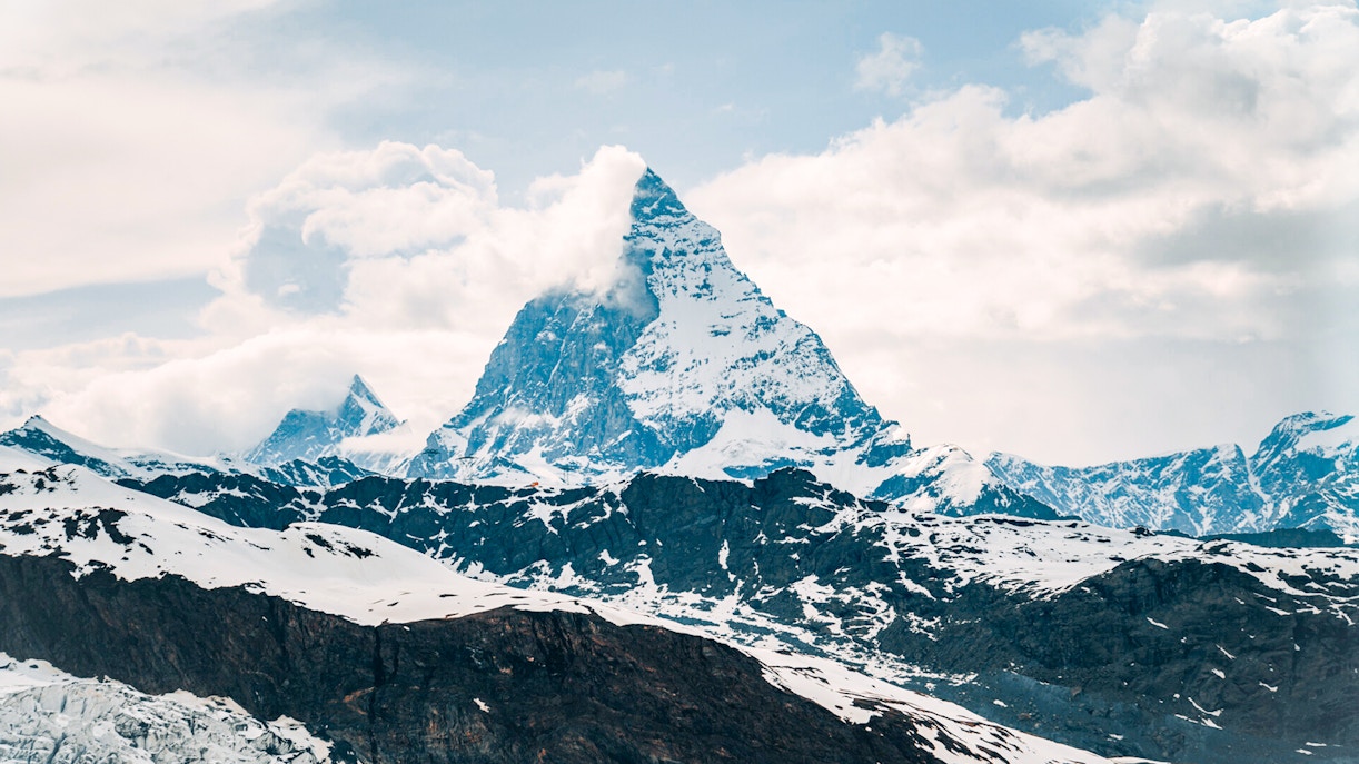 Matterhorn peak surrounded by snow and clouds in the Swiss Alps.