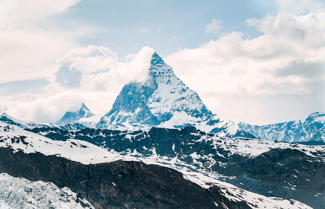 Matterhorn peak surrounded by snow and clouds in the Swiss Alps.