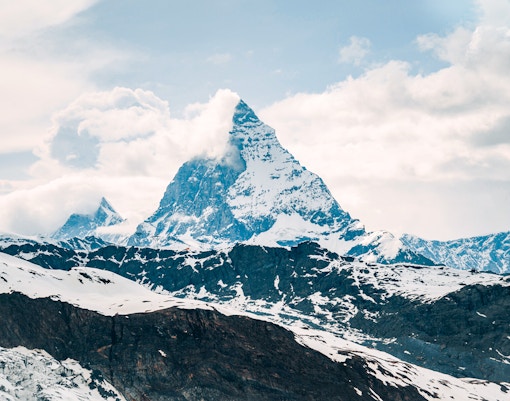 Matterhorn peak surrounded by snow and clouds in the Swiss Alps.