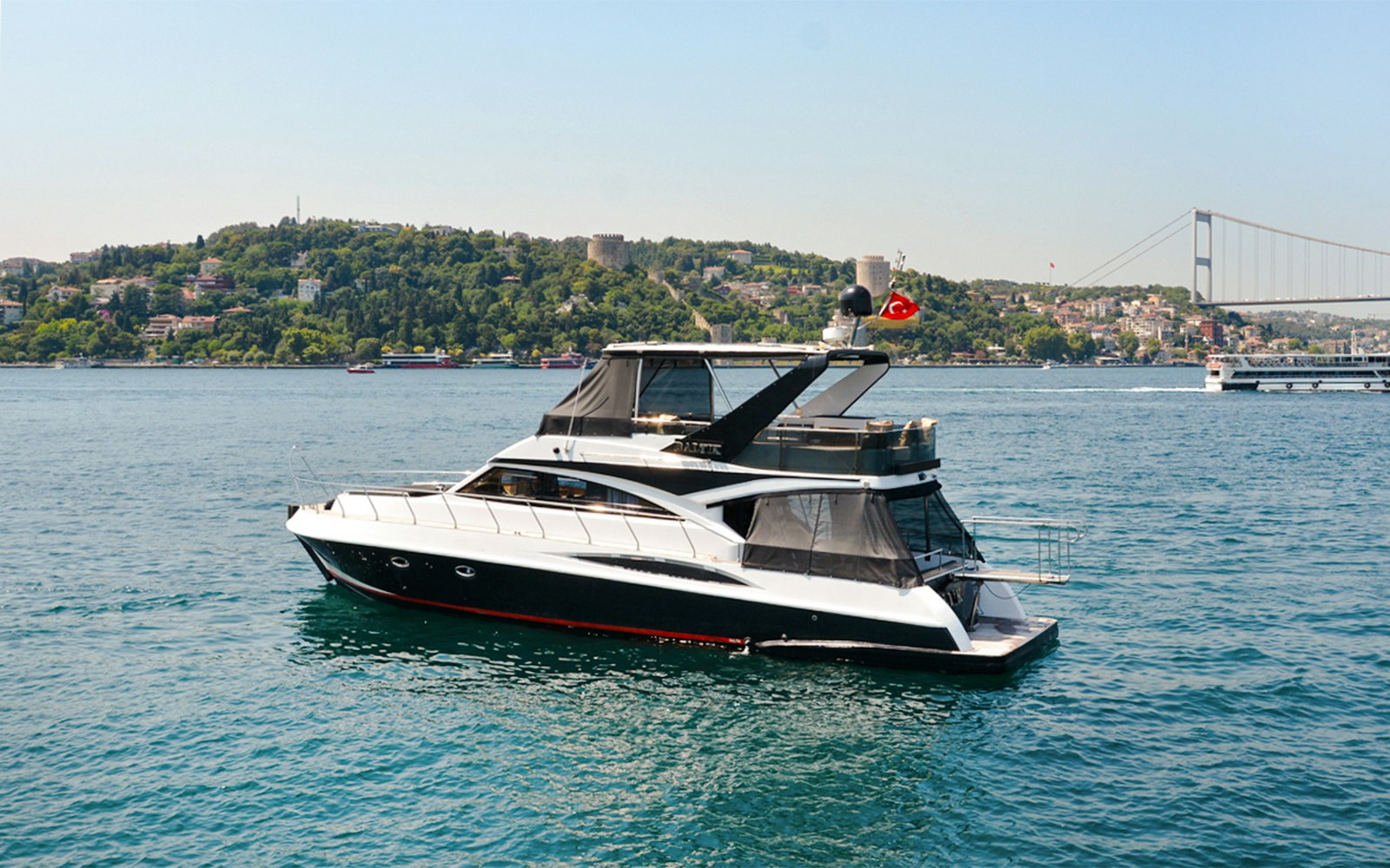 Luxury private yacht cruising on the Bosphorus with Istanbul skyline in the background.