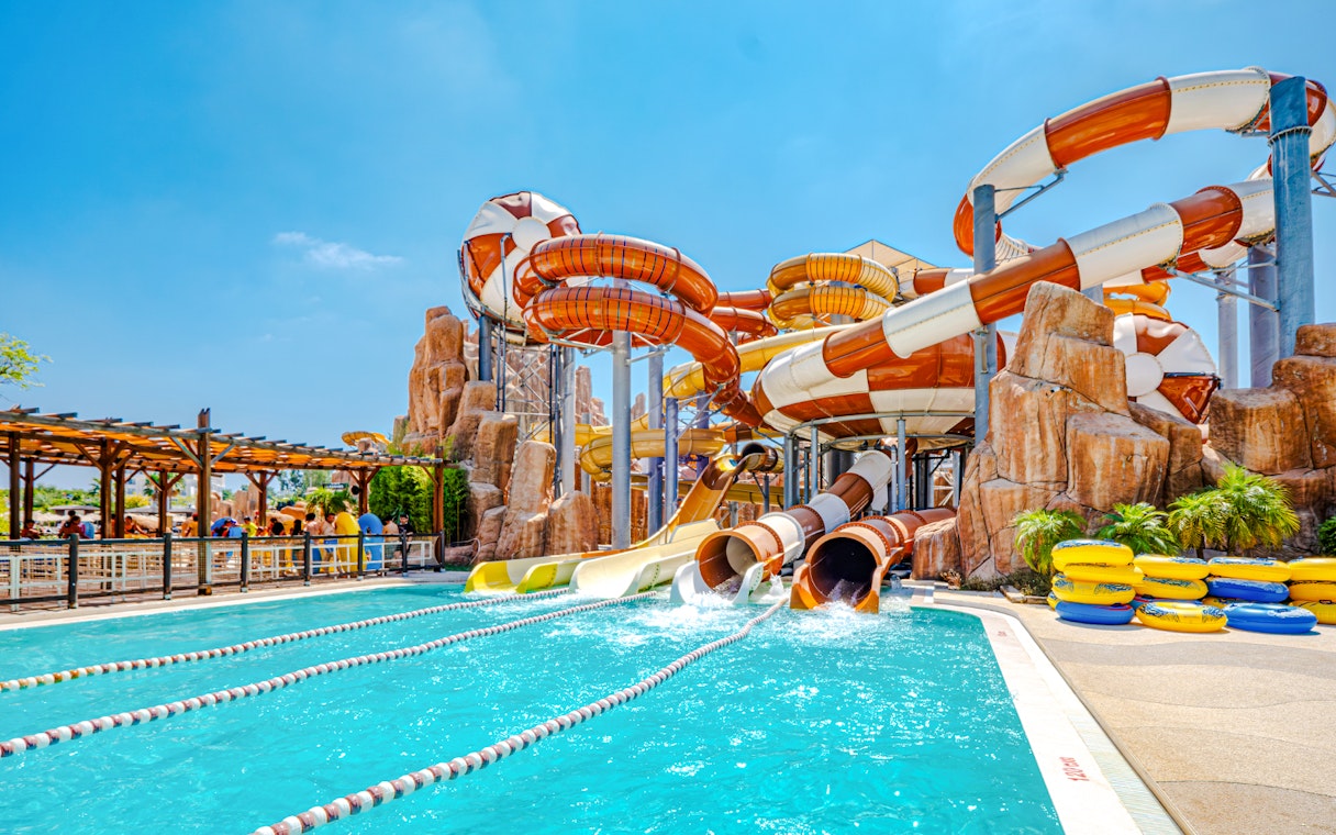 Water slides at The Land of Legends theme park with a pool and colorful tubes.