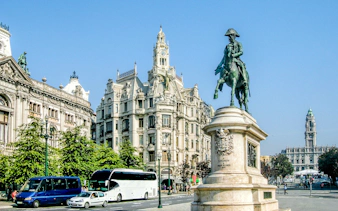 Statue of Dom Pedro IV on horseback in Porto's Avenida dos Aliados with historic buildings.