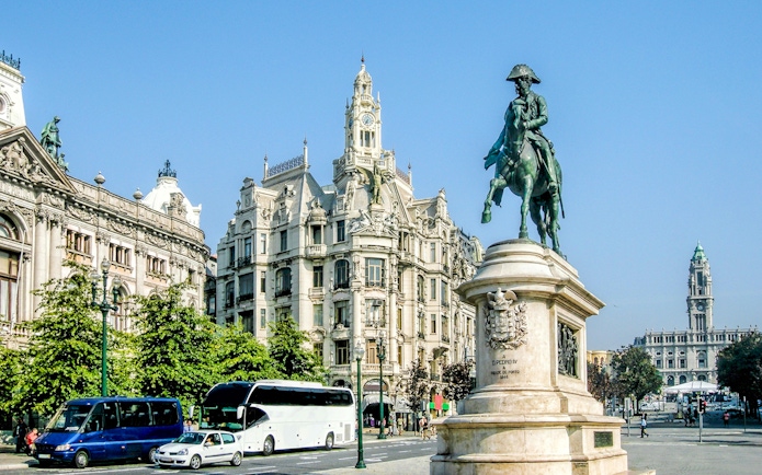 Statue of Dom Pedro IV on horseback in Porto's Avenida dos Aliados with historic buildings.
