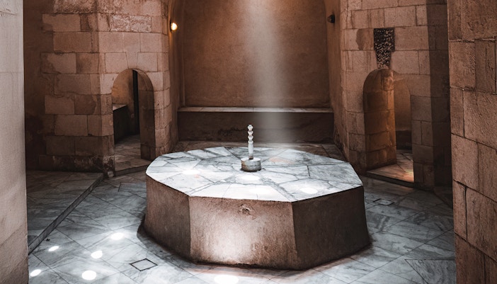 Traditional Turkish hammam interior with marble basins and domed ceiling in Istanbul.