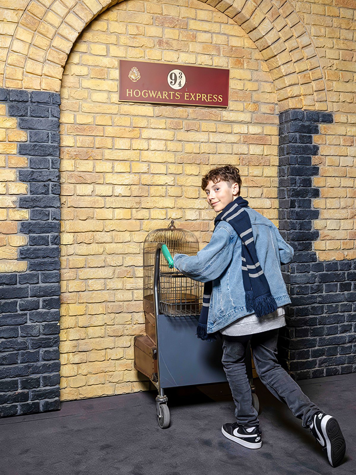 Tourist pushing trolley at Platform 9¾, Harry Potter set, London.